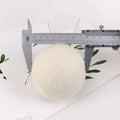 Wool laundry drying ball in various sizes with cotton storage bag for tumble dryer use