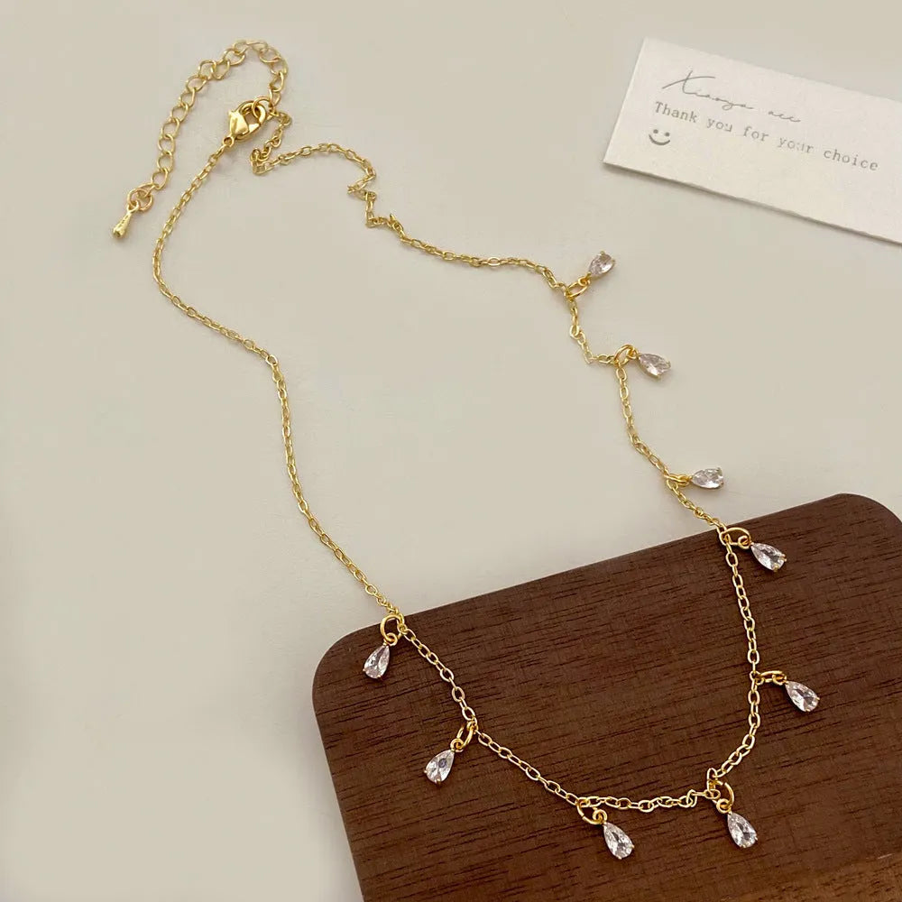 Women's zircon necklace, earrings, and anklet set with geometric pendant on a regular chain.
