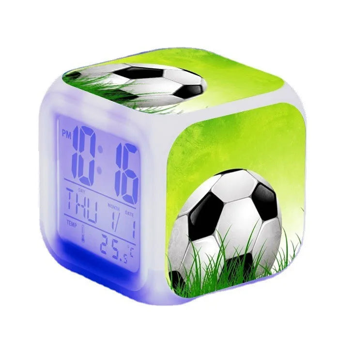Square cartoon football pattern children's alarm clock with mute alarm on a bedside table.