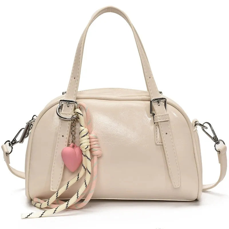 Soft PU women's shoulder bag in shell shape with sandwich pocket, shown in black with pendant strap.