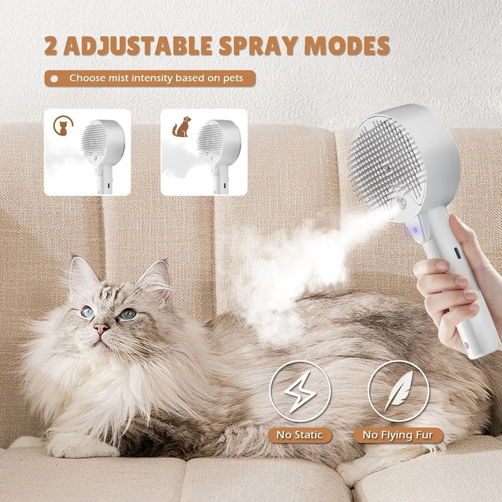 Pink and white cat steam brush with water tank, stainless steel comb, and control buttons for mist and cleaning.