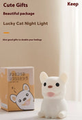 A cartoon bull-shaped silicone USB night light with a dimming function on a bedside table.