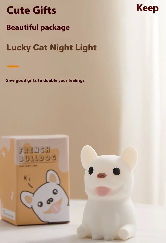 A cartoon bull-shaped silicone USB night light with a dimming function on a bedside table.