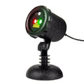 Christmas laser projector projecting red and green laser firefly patterns onto a garden tree at night, IP65 outdoor use