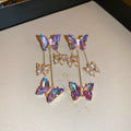 Silver needle and crystal flower earrings with blue purple butterfly tassel on alloy hooks.