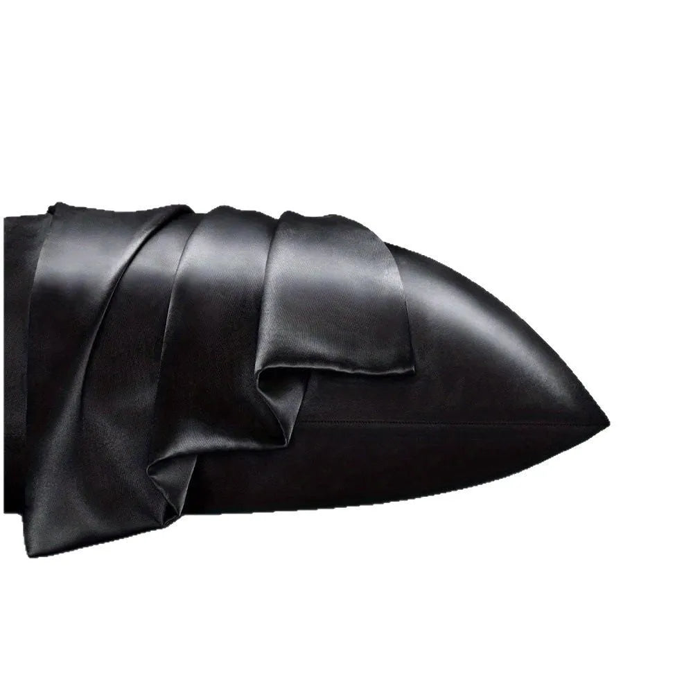 A pair of solid colour satin cloth pillowcases in a choice of sizes on a bed.