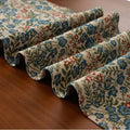 Dark blue Nordic stripe pattern jacquard table runner with tassel detail on a wooden table.