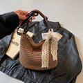 Women's woven straw messenger bag in khaki colour, showing hollowed texture and single shoulder strap.