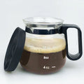 Transparent borosilicate glass coffee maker with black silicone lid on a stovetop
