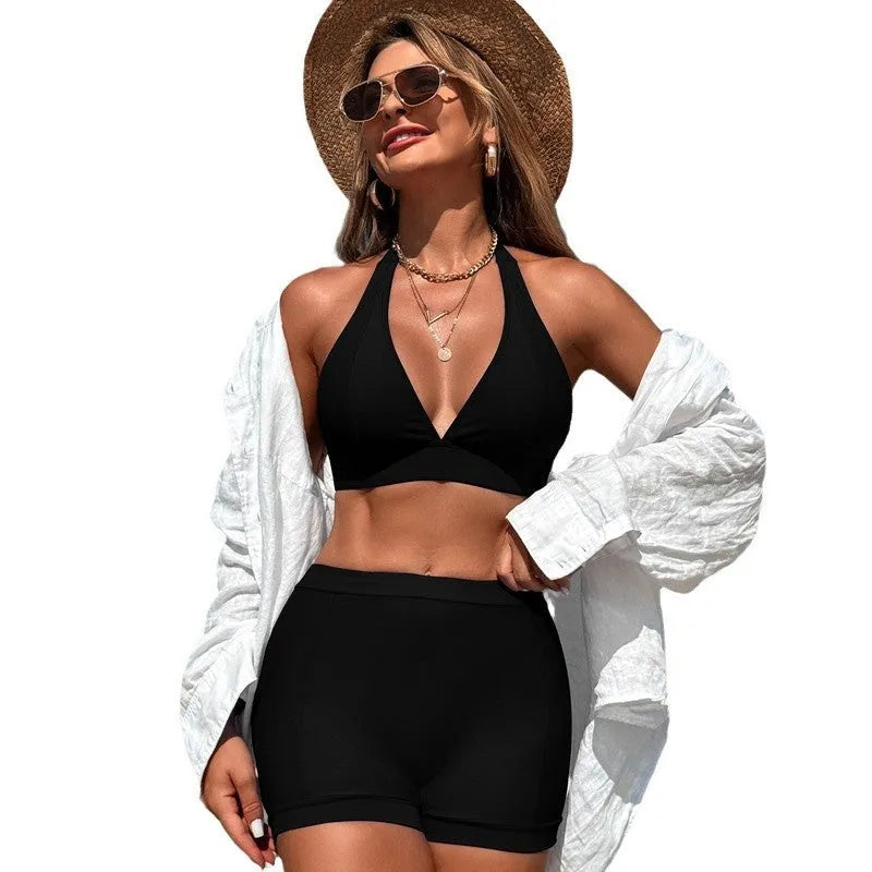 Women's black bikini swimsuit laid flat, showing sleeveless design and split bottom.