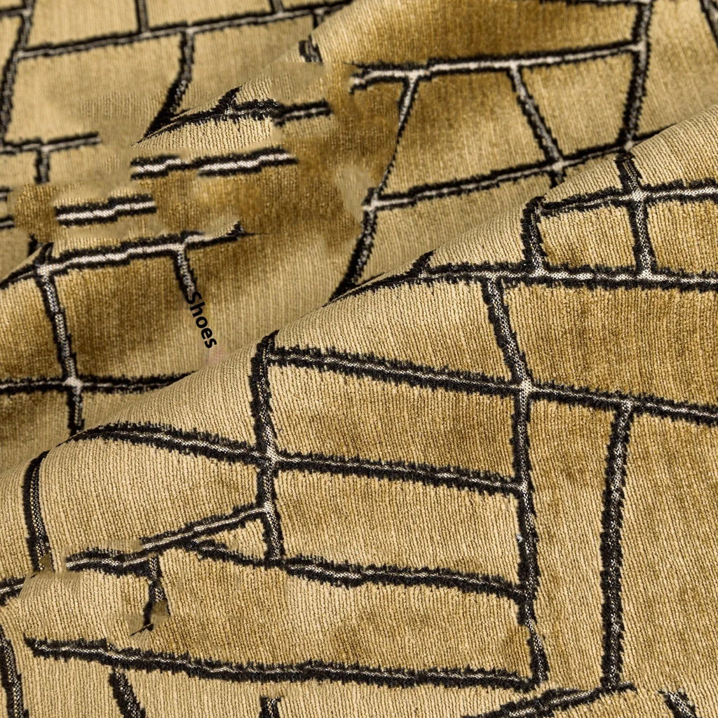 Geometric patterned cushion covers in gold colour on a grey sofa.