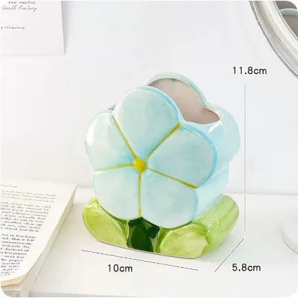 Ceramic floral pen holder box in pink tulip design on a desk.