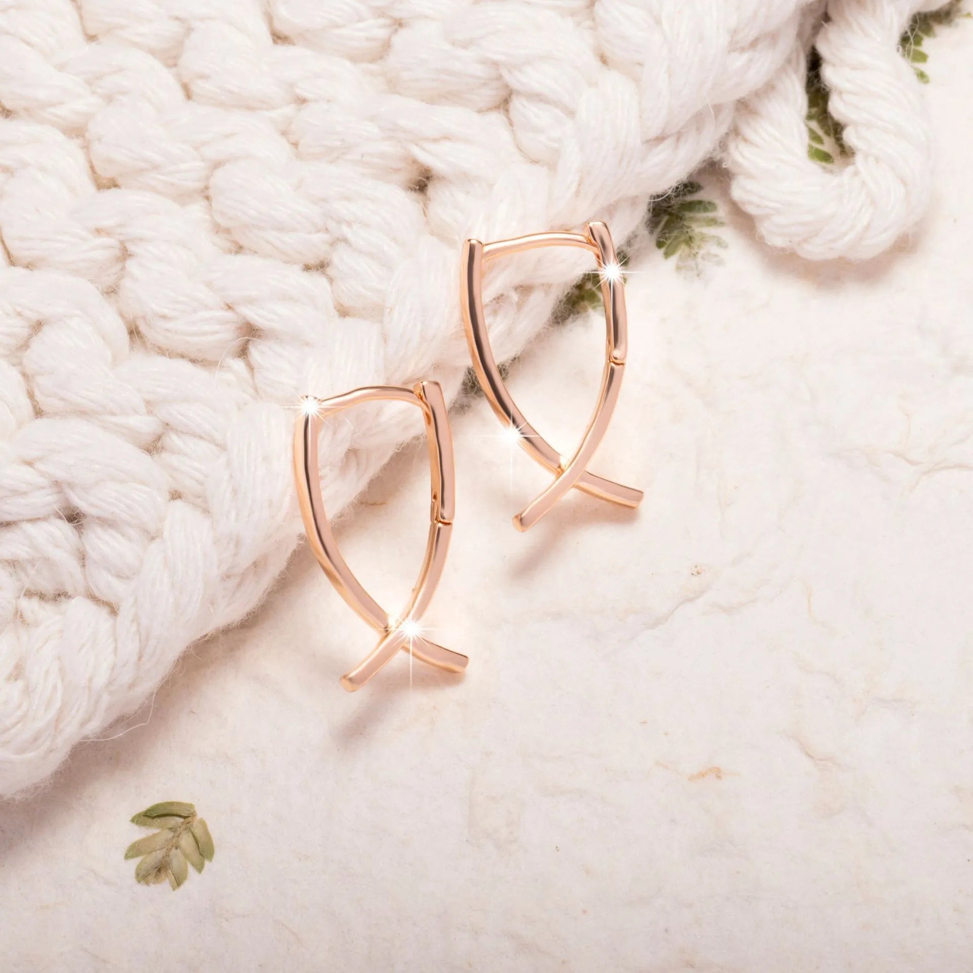 Rose gold plated cross-shaped earrings showing front design with post fitting.