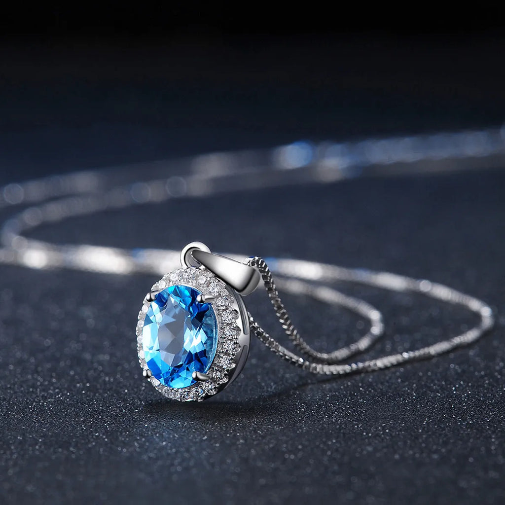 Geometric design women's sterling silver and blue topaz jewellery set showing earrings, ring, pendant, and necklace.