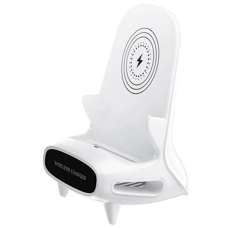White mini chair-shaped wireless phone charger on a desk, with phone seated on it.