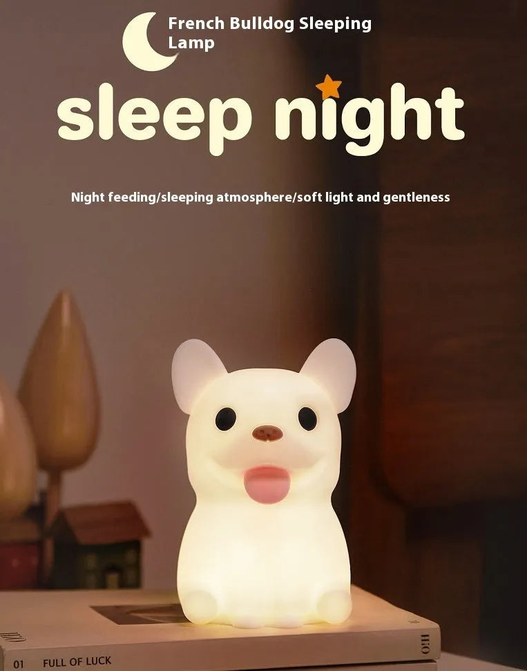 A cartoon bull-shaped silicone USB night light with a dimming function on a bedside table.