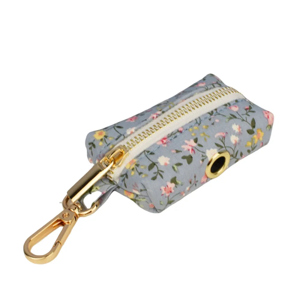 Floral print dog collar and leash set with matching bow, vest, and poop bag holder.
