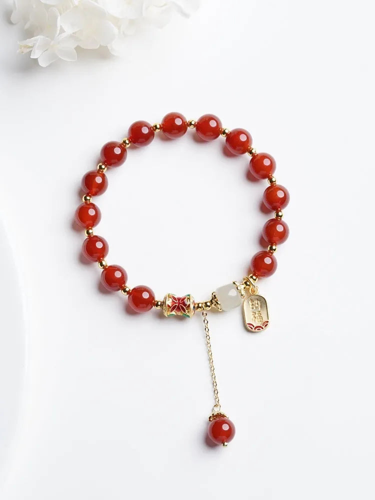 Women's bracelet with red agate and Hetian jade beads on gold-plated links in three design styles.