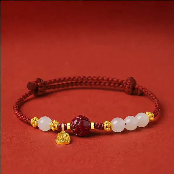 Adjustable silver bracelet with red Hetian jade detail on a wrist.