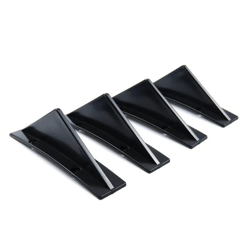 Black triangular car rear spoiler on a white background, shown with screws and adhesive tape.