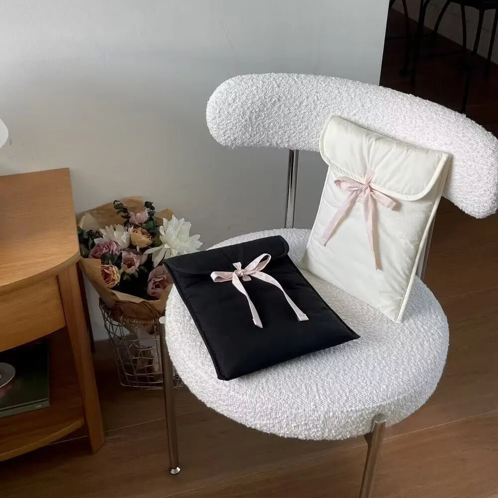 Black and white women's quilted nylon laptop bag with a ballet-style bow.