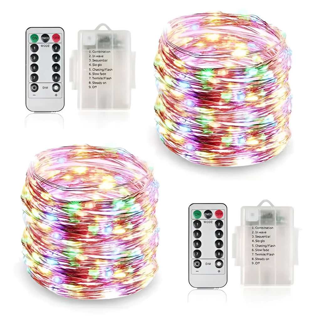 Close-up of bendable copper wire fairy lights with small LEDs, showing battery box and USB cable on a wooden surface.
