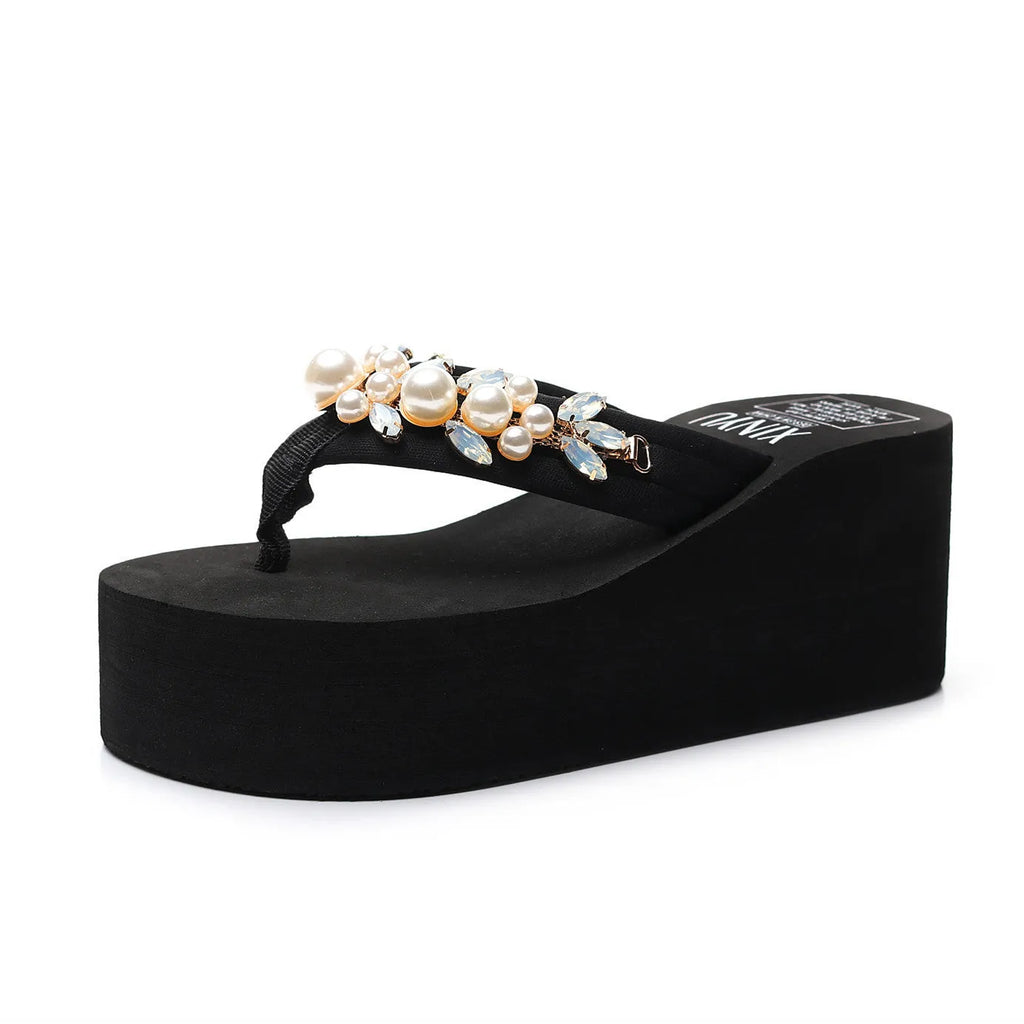 Women's beige high-heeled flip-flops with a cotton cloth upper on a summer background.