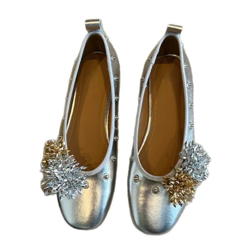 Women's silver Mary Jane loafers with flower rivets, buckle strap, round toe, and flat rubber sole.