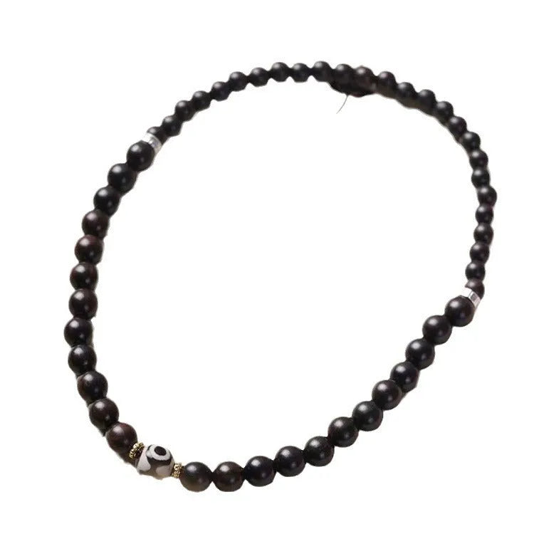 Close-up of Tibetan-style ebony wood bead bracelet showing 8mm diameter beads in two-circle layered design