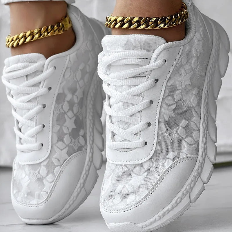 Women's white canvas casual running shoes with flat sole on a light background.
