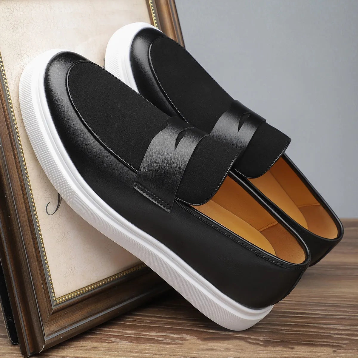 Black men's slip-on Gommino casual shoes with tassel detail on round toe.