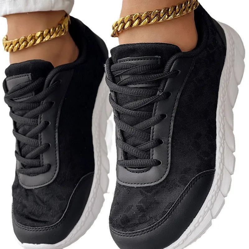 Women's white canvas casual running shoes with flat sole on a light background.