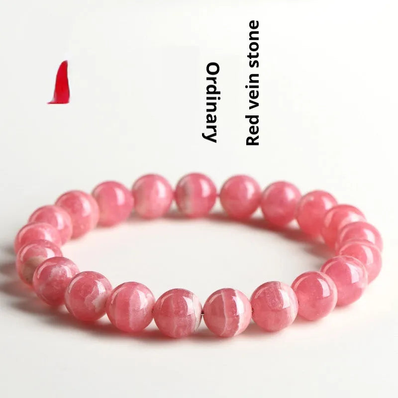 Close-up of a women's geometric red crystal bracelet with a longevity lock on a wrist.