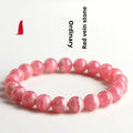 Close-up of a women's geometric red crystal bracelet with a longevity lock on a wrist.