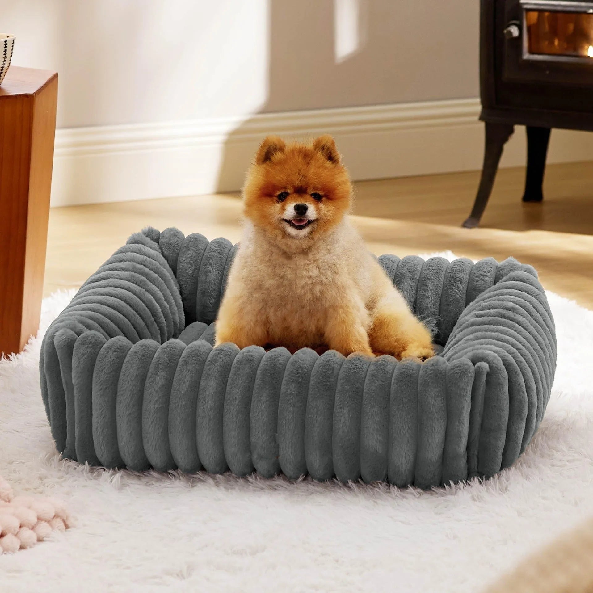 Beige raised cushion pet bed for a medium-sized dog on a wooden floor.