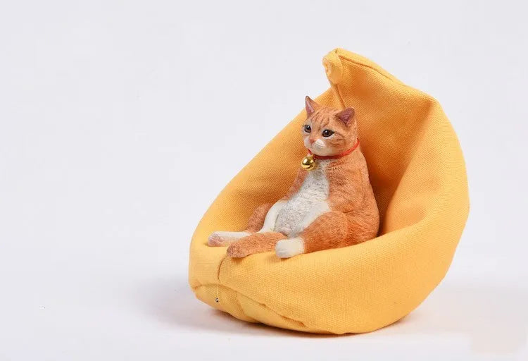 Small resin cat figurine on a sofa, a 1:6 scale car dashboard ornament.