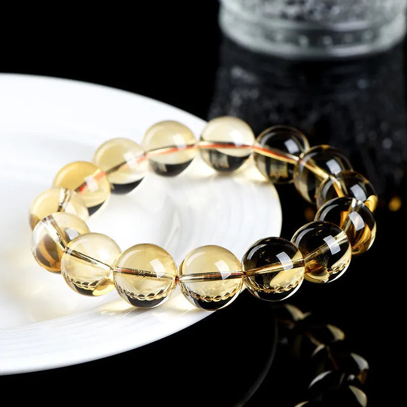 Natural yellow citrine scattered beads bracelet on a wrist, showing polished gemstones on a knotted cord.