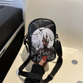 Black Halloween crossbody bag with orange pumpkin, white ghost, and black bat graffiti print, shown on adjustable strap.