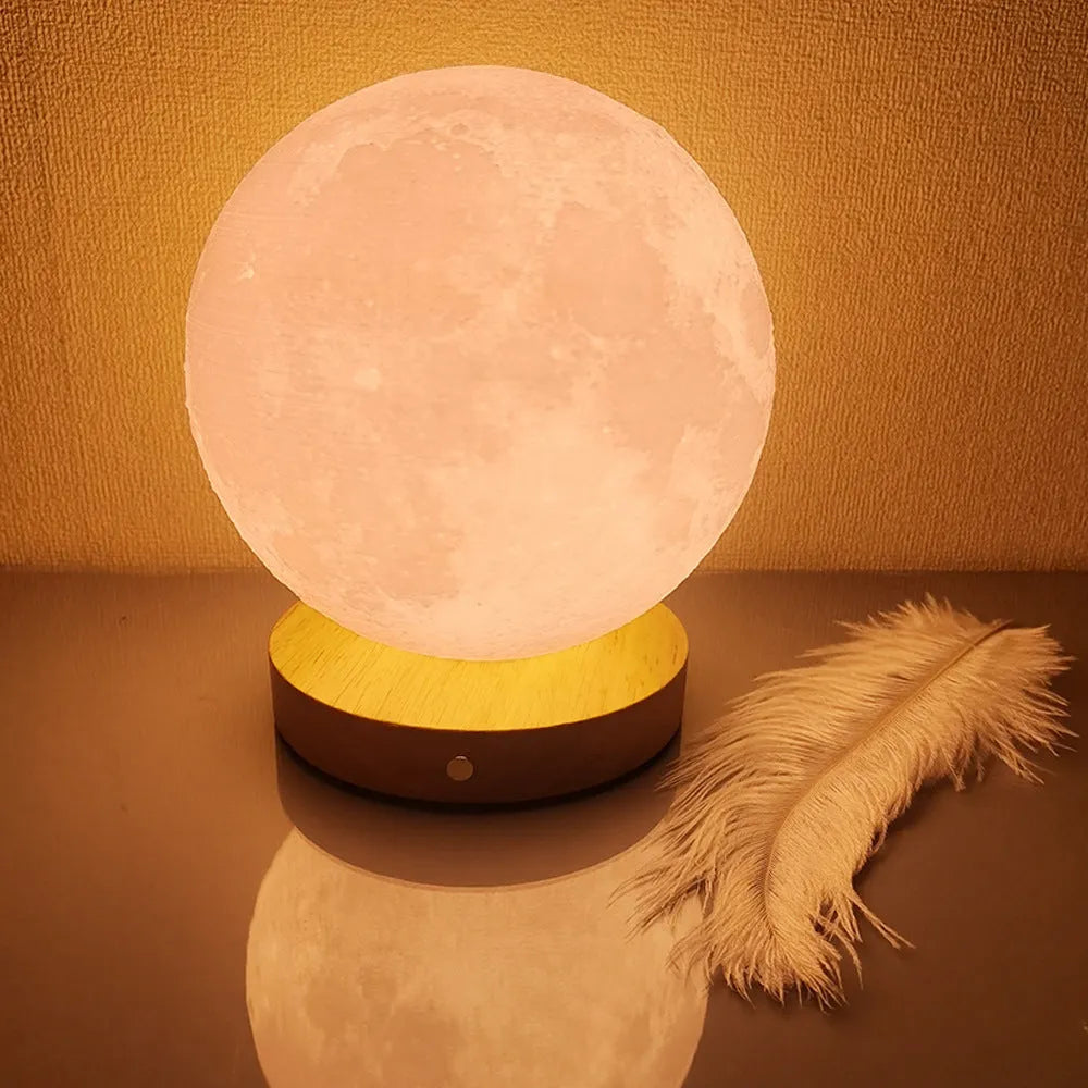Rotating moon night light on wooden base showing three colour options and size scale