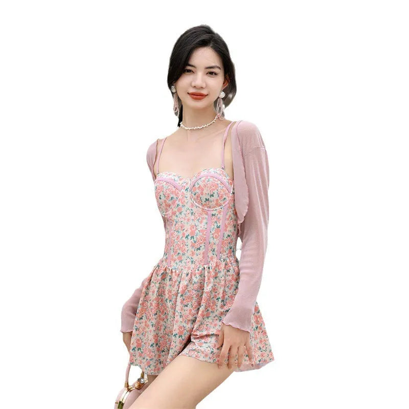 Women's pink floral jumpsuit swimsuit with adjustable suspender straps on mannequin