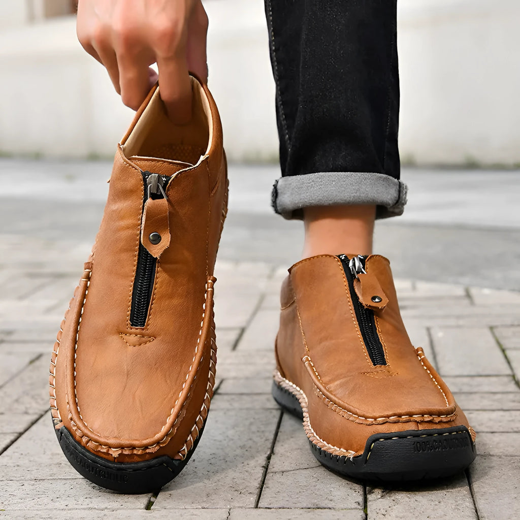 Men's black slip-on loafers with round toe and rubber sole on a white background.