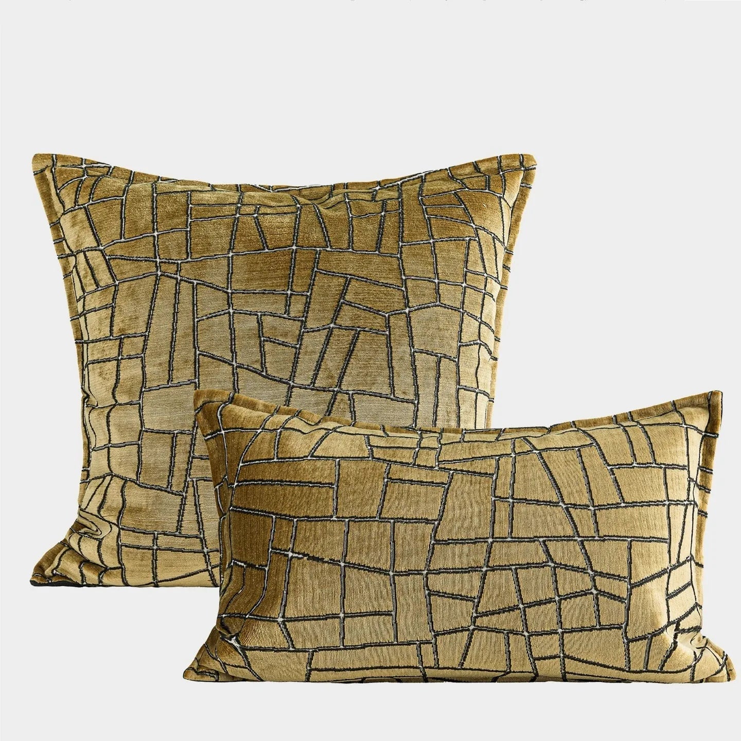 Geometric patterned cushion covers in gold colour on a grey sofa.