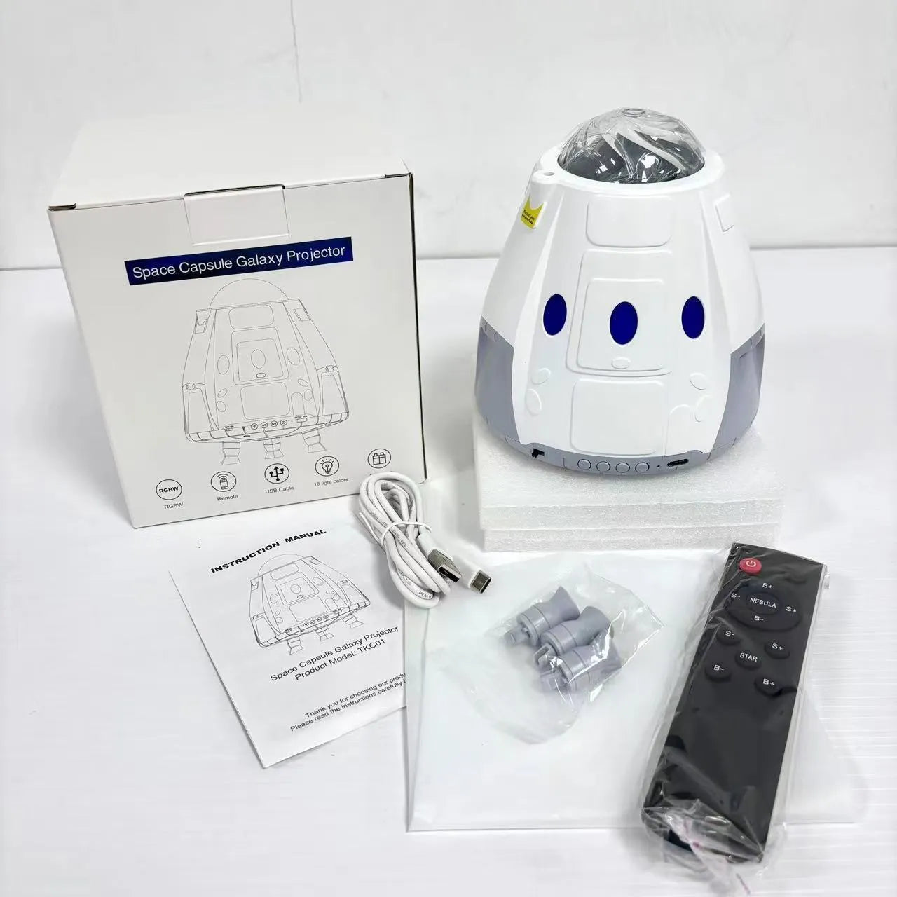 Space capsule shaped USB projection lamp showing galaxy light effect on a wall