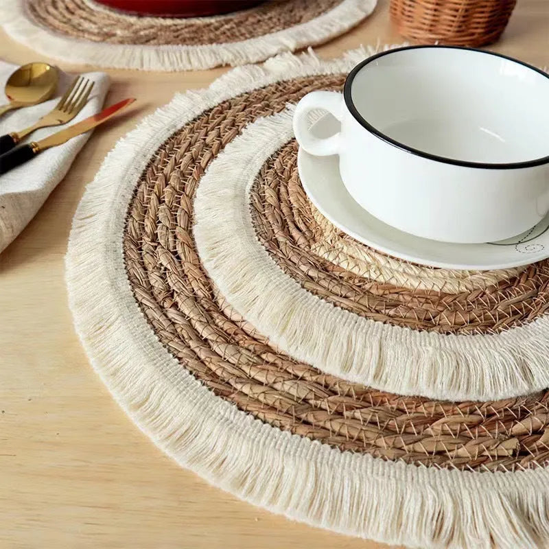 Round Japanese straw placemat with tassel edge on dining table