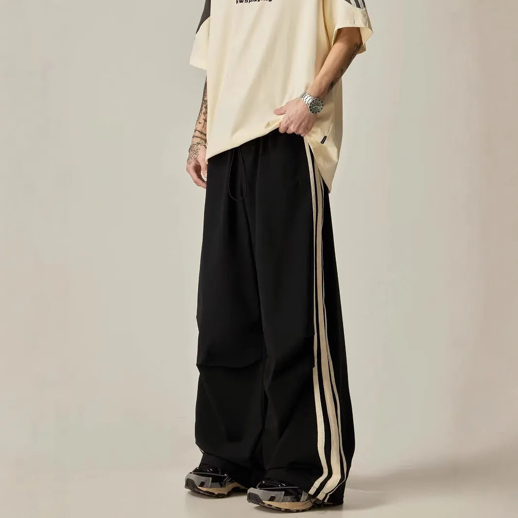 Black men's wide-leg climbing trousers with a high waist on a hanger.