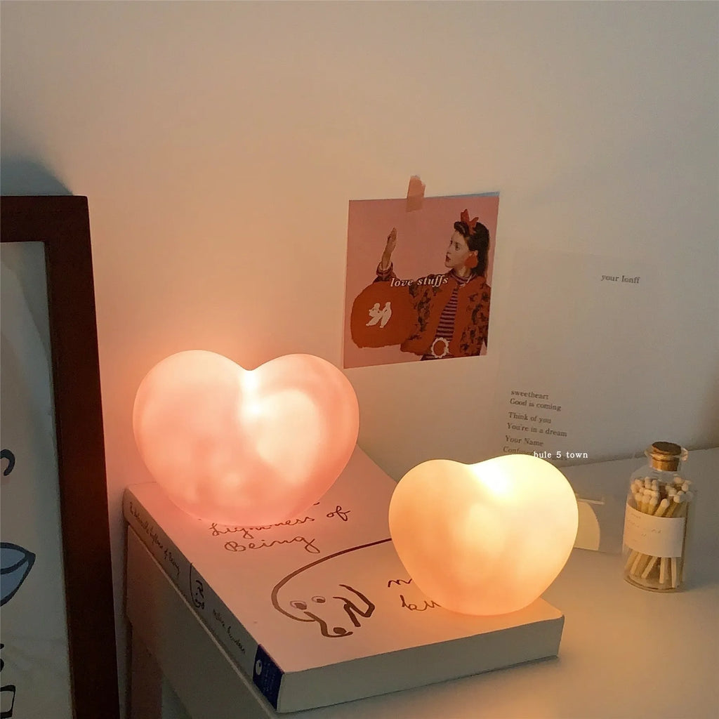 White and pink vinyl atmosphere lamp in trumpet and tuba shapes on a bedside table.
