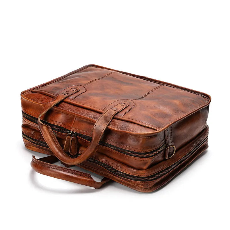Brown vintage men's leather briefcase open to show internal laptop, document, and camera pockets.