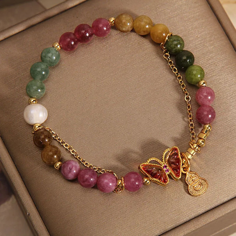 Natural jade coloured agate bracelet with a butterfly gourd tourmaline charm on an elasticated cord.