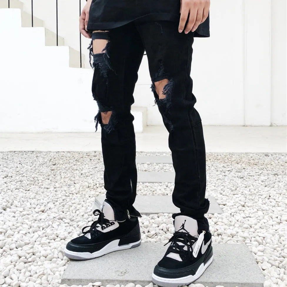 Men's black torn jeans in cotton elastic denim with raw edges, medium to low waist and zipper placket, sizes M to 2XL.