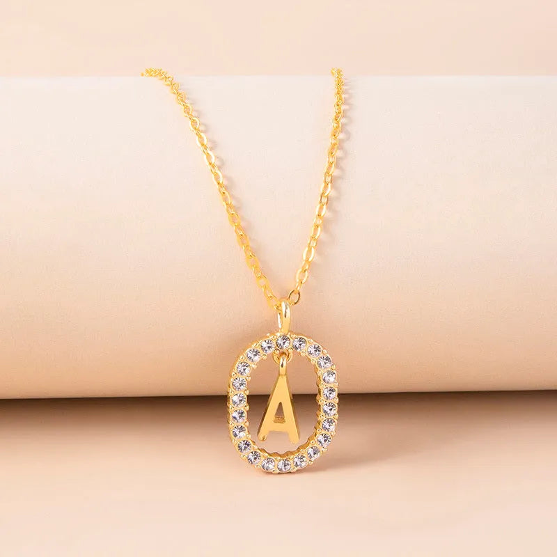 Gold crystal letter necklace with rhinestone initial on oval pendant and O-chain